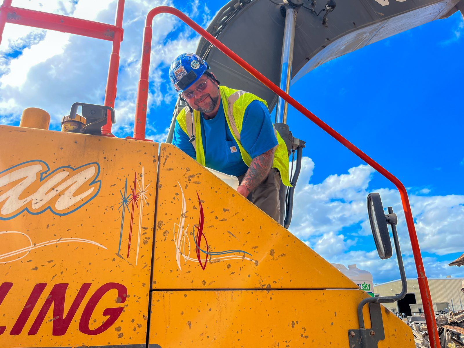 NADC equipment operator climbing aboard an excavator on a sunny jobsite