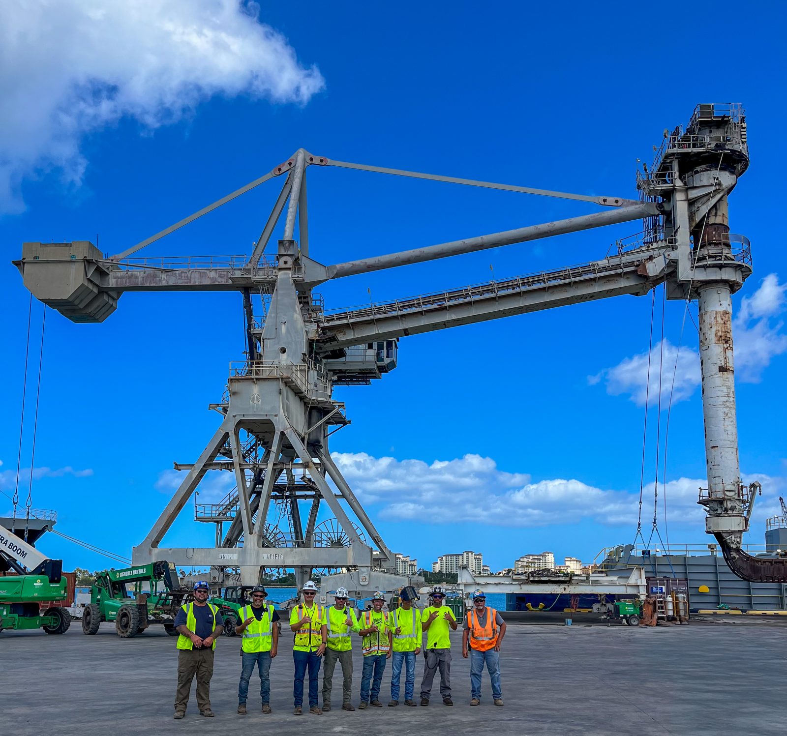NADC crew posing in front of a dockside ship unloader before its removal