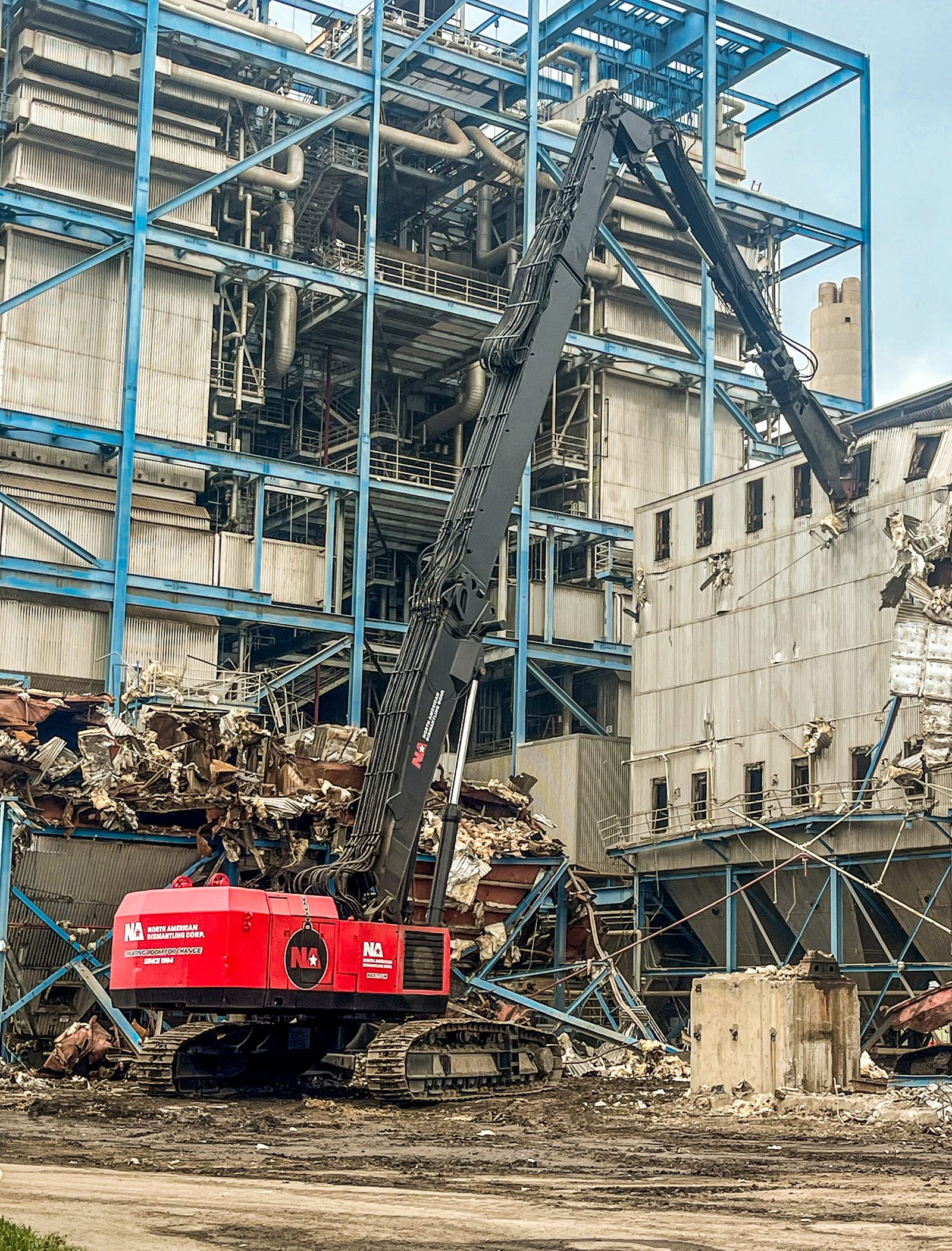 NADC high-reach excavator working against the steel boiler structure of a power plant