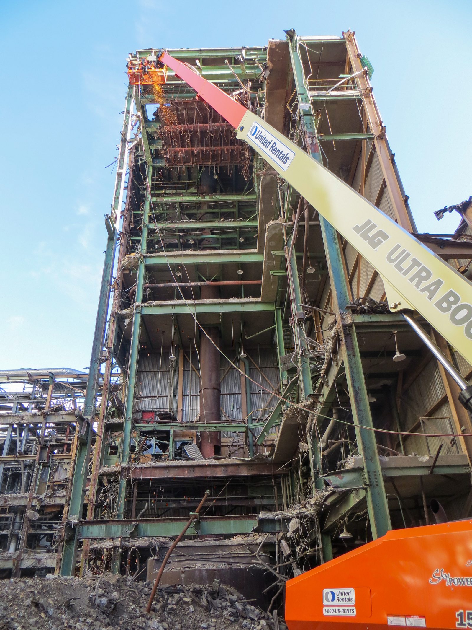 Torch cutting from a boom lift inside the recovery boiler building steel frame at the Glatfelter mill