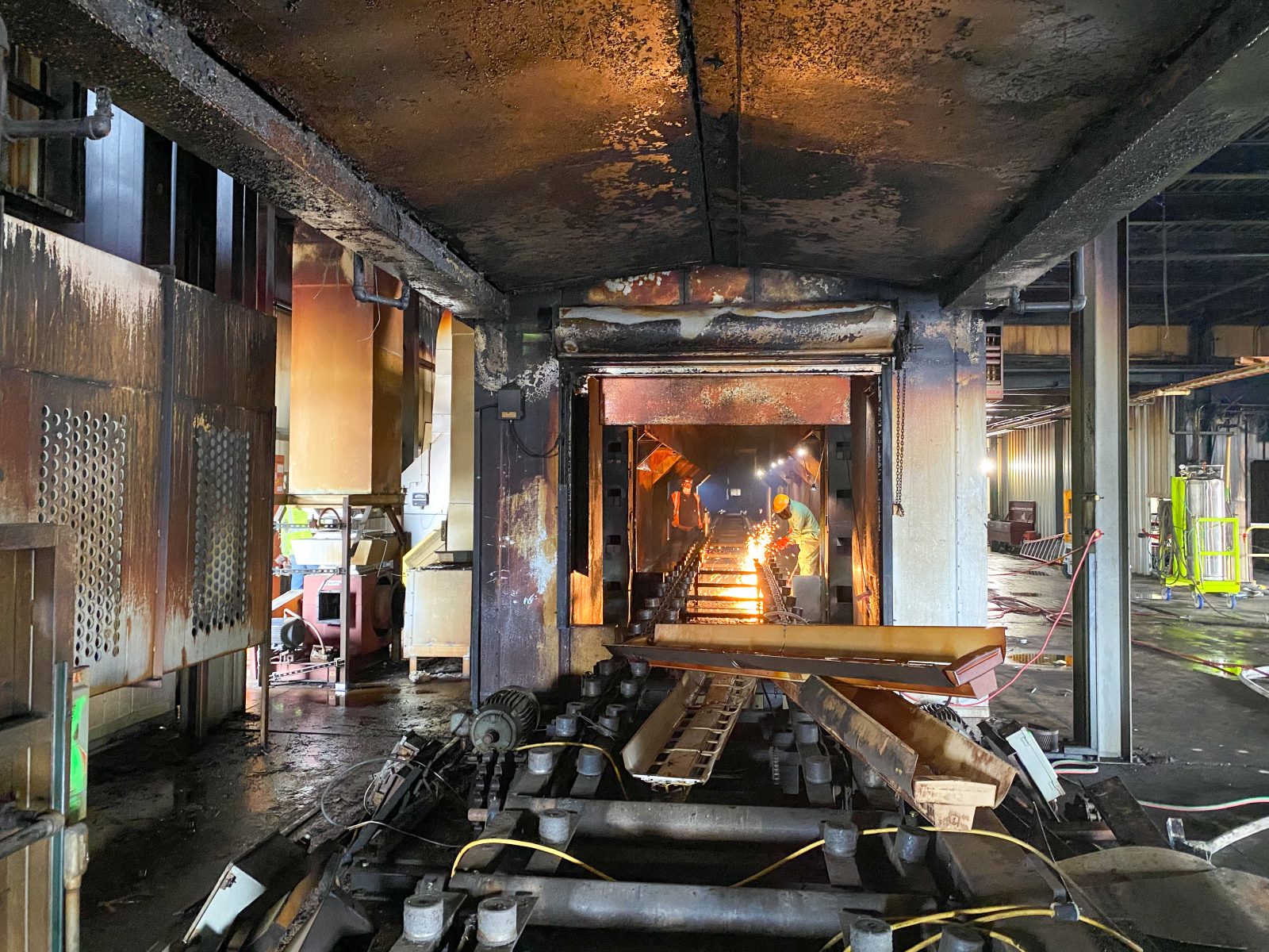 NADC crews torch-cutting inside an oven section during rooftop equipment removal at the Michigan Assembly Plant