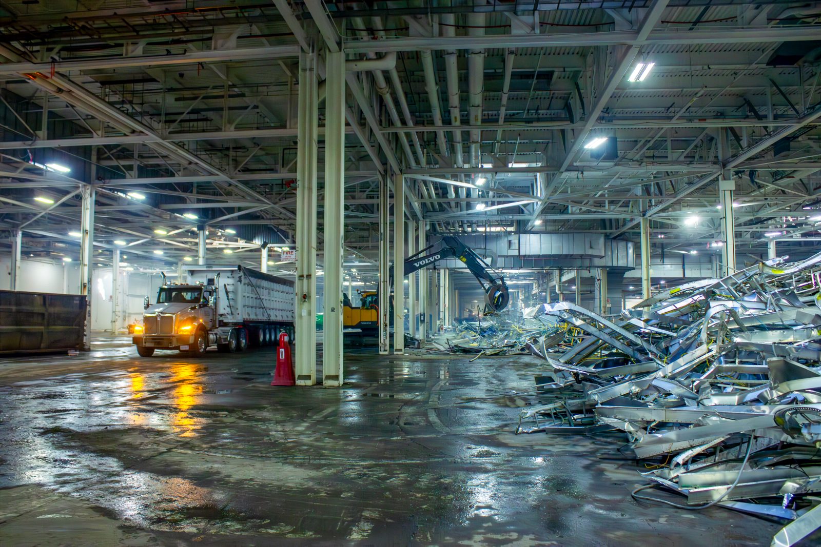 Excavator and haul truck handling stripped-out scrap inside the Orion Assembly Paint Shop