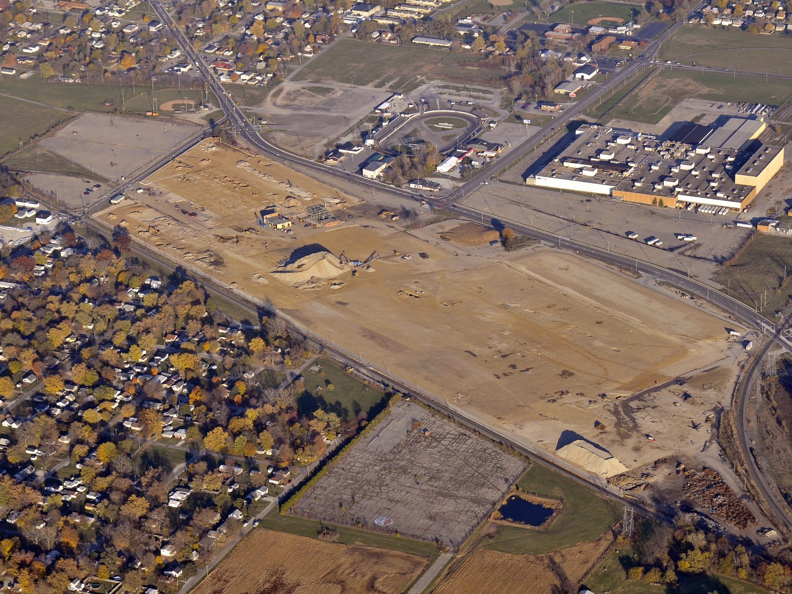 Aerial view of a large cleared and graded former industrial site beside a town